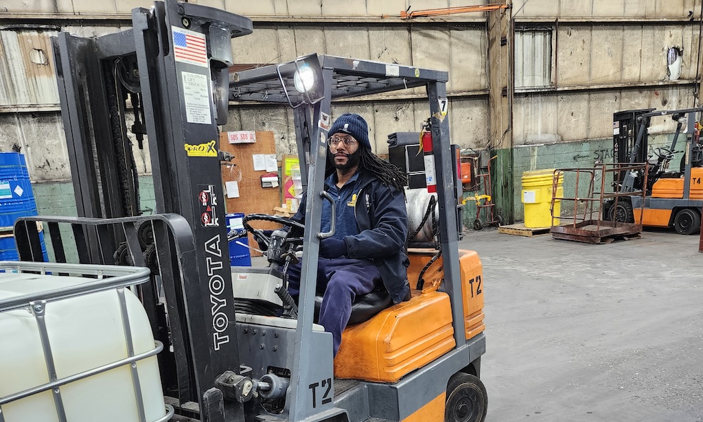Employee operating a forklift in a 3PL warehouse in New Jersey, transporting materials efficiently within an industrial setting.