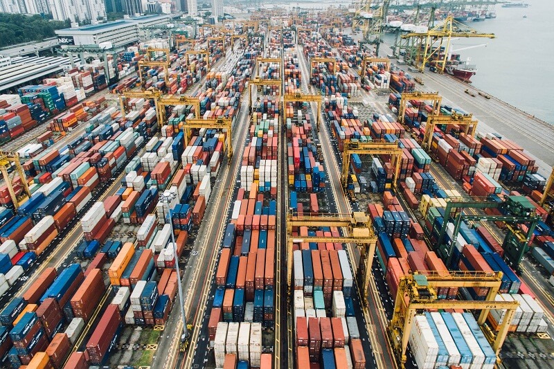 Aerial view of a shipping logistics hub with packed shipping containers and cranes in New Jersey, showcasing extensive shipping and logistics capabilities.